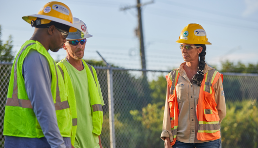 three people in safety gear outside